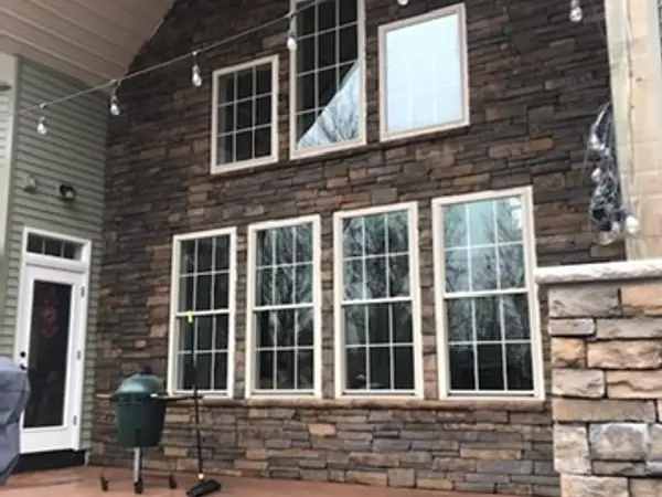 Finished concrete patio under a covered porch with stone veneer walls