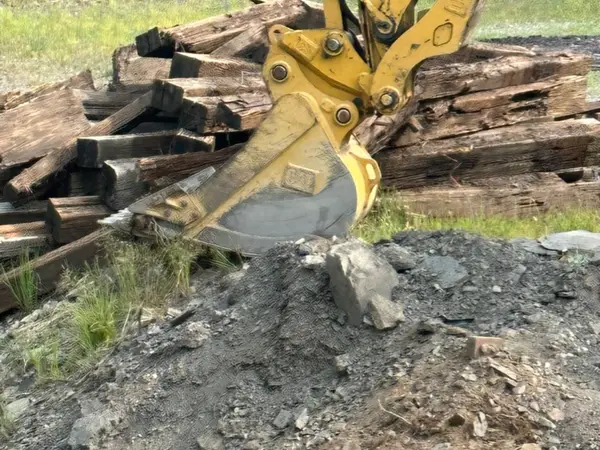 Excavator removing the old timber bridge structure