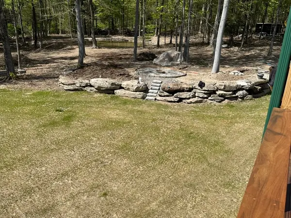 Natural boulder retaining wall at the edge of a newly graded lawn