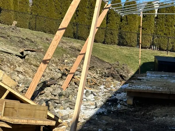 Old timber deck structure being removed beside the hillside
