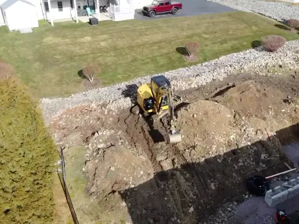 Aerial view of a mini excavator digging the wall footprint