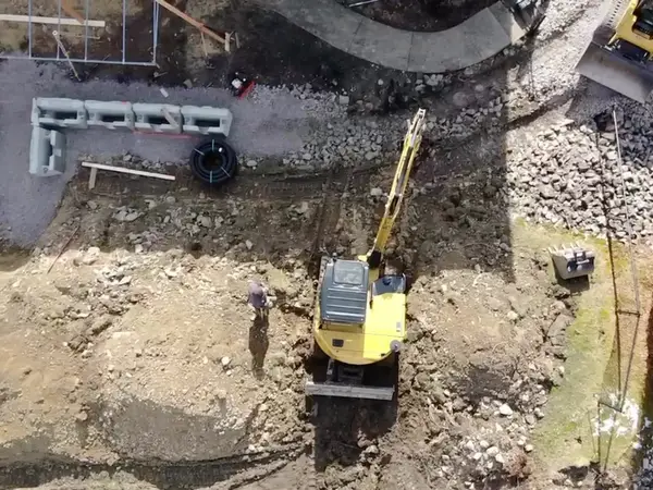 Aerial view of the excavator setting blocks along the lower wall