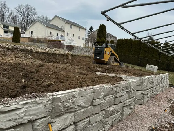 Lower wall courses backfilled with stone and the yard graded behind