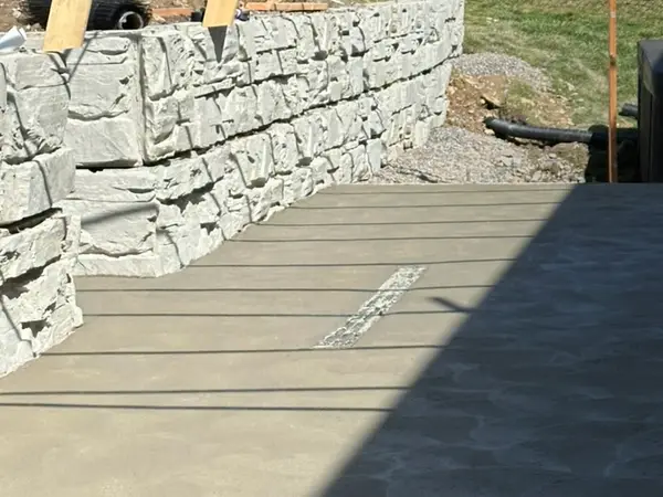 New concrete slab poured against the lower Magnum Stone wall